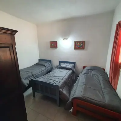 a room with two twin beds and a couch at El Cartucho in Villa General Belgrano