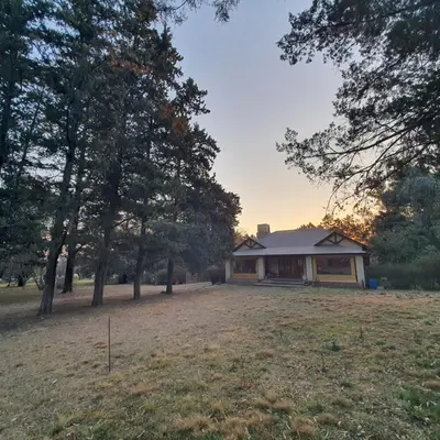 a house in the middle of a field with trees at El Cartucho in Villa General Belgrano