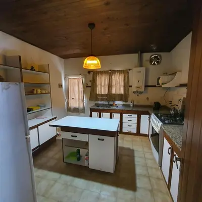 a kitchen with white cabinets and a blue counter top at El Cartucho in Villa General Belgrano