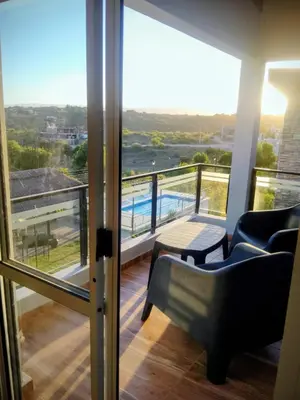 a room with a balcony with a view of a pool at Encanto Serrano II in Villa Carlos Paz