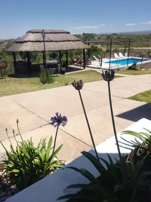 a garden with a pool and a gazebo at Encanto Serrano II in Villa Carlos Paz