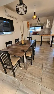 a wooden table and chairs in a living room at Encanto Serrano II in Villa Carlos Paz
