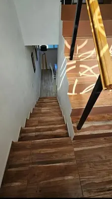 a staircase with wood floors and a yellow railing at Encanto Serrano II in Villa Carlos Paz