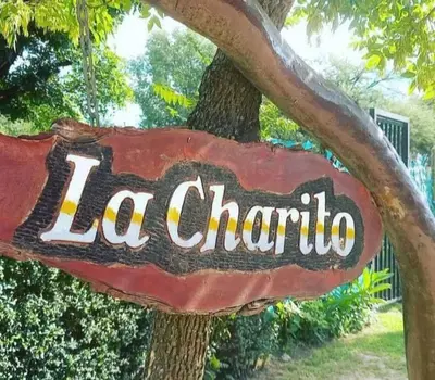 a sign for a la chattoria hanging from a tree at La Charito in Villa Cura Brochero