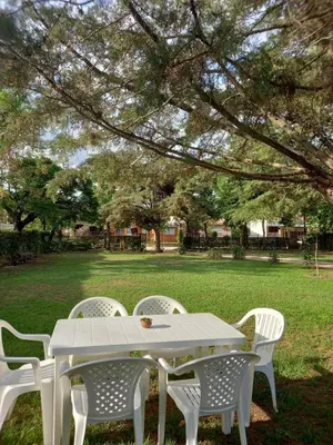 a white table and chairs under a tree at La Charito in Villa Cura Brochero