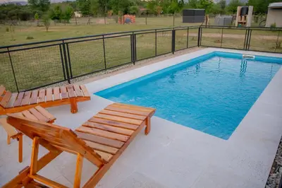 a swimming pool with two deck chairs and a pool at Aires de Paz in Las Calles