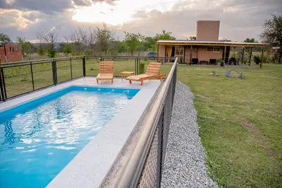 a swimming pool with two chairs and a fence at Aires de Paz in Las Calles