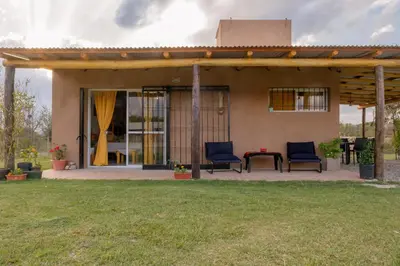 a house with two chairs and a table in a yard at Aires de Paz in Las Calles