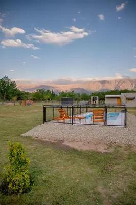 a fence with benches in a field with mountains in the background at Aires de Paz in Las Calles