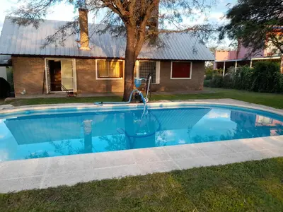a swimming pool in front of a house at Mis tres estrellas in Villa Los Aromos
