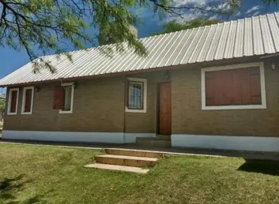 a small brick house with a red door at Mis tres estrellas in Villa Los Aromos
