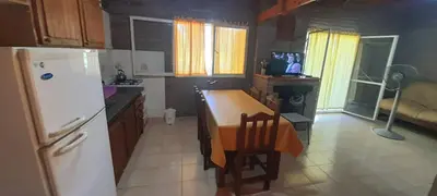 a kitchen with a white refrigerator and a table with chairs at Mis tres estrellas in Villa Los Aromos