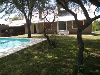a house with a pool and trees in the yard at Mis tres estrellas in Villa Los Aromos