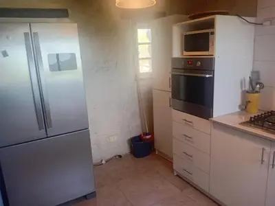 a kitchen with a refrigerator and a stove top oven at Casa on the rock's in Nono