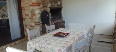 a dining room with a table and chairs and a fireplace at Casa on the rock's in Nono