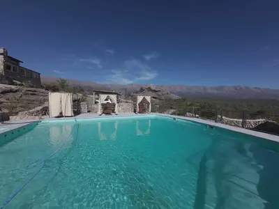 a large swimming pool with a mountain in the background at Casa on the rock's in Nono