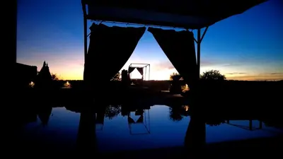 a silhouette of a tent with the sunset in the background at Casa on the rock's in Nono
