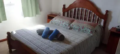a bed with two blue pillows on it at Casa on the rock's in Nono