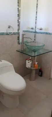 a bathroom with a toilet and a glass sink at Casa on the rock's in Nono