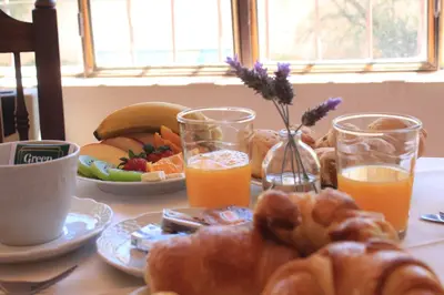 a table with a breakfast of bread and orange juice at Alta Gracia Hotel Boutique in Alta Gracia