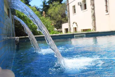 a water fountain in a pool in a yard at Alta Gracia Hotel Boutique in Alta Gracia
