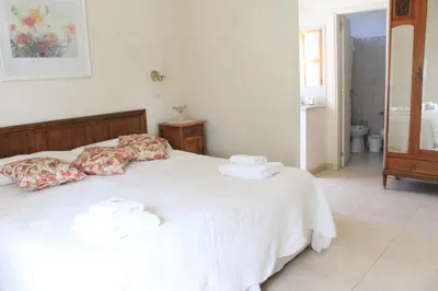 a bedroom with a white bed with towels on it at Alta Gracia Hotel Boutique in Alta Gracia