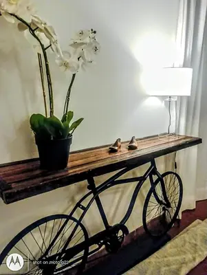 a bike on a wooden table with a plant on it at Madaro House in San Antonio de Arredondo