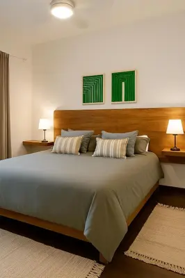 a bedroom with a large bed with two lamps at Madaro House in San Antonio de Arredondo