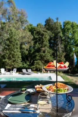 a table with two plates of food next to a pool at Madaro House in San Antonio de Arredondo