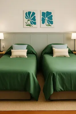 two beds in a room with green sheets and pillows at Madaro House in San Antonio de Arredondo