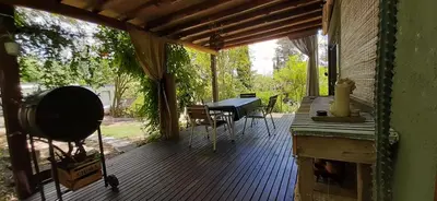 a wooden porch with a table and a table at Vista Alago in Villa Ciudad Parque