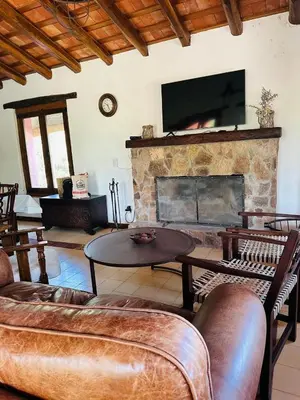 a living room with a fireplace with a flat screen tv at La Buyi, Casa de Campo mirando al Champaqui in San Javier