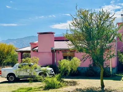 a truck parked in front of a pink house at La Buyi, Casa de Campo mirando al Champaqui in San Javier