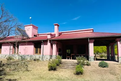 a pink house with a staircase in front of it at La Buyi, Casa de Campo mirando al Champaqui in San Javier