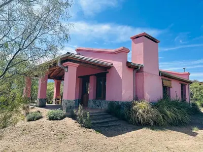 a pink house in the middle of a field at La Buyi, Casa de Campo mirando al Champaqui in San Javier