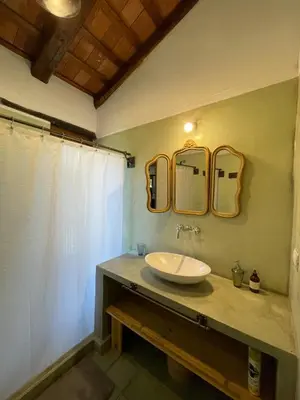 a bathroom with a sink and two mirrors on the wall at La Buyi, Casa de Campo mirando al Champaqui in San Javier