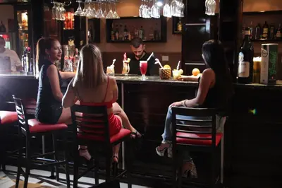a group of people sitting at a bar at El Condor Hotel SPA in Merlo