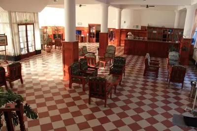 a room with chairs and tables and a checkered floor at El Condor Hotel SPA in Merlo