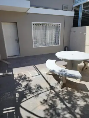 a white table and bench in a room with a window at Departamento Champaqui in Villa Carlos Paz