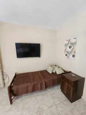 a bedroom with a bed and a flat screen tv at Departamento Champaqui in Villa Carlos Paz