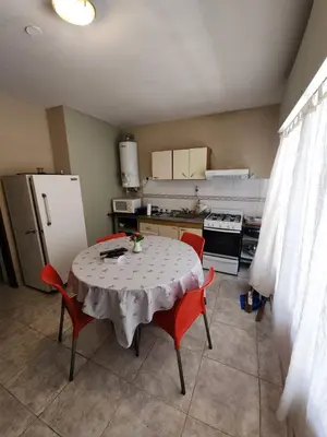 a kitchen with a table and chairs and a refrigerator at Departamento Champaqui in Villa Carlos Paz