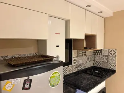 a kitchen with white cabinets and a refrigerator at Central & Comfy Apt in Córdoba in Cordoba