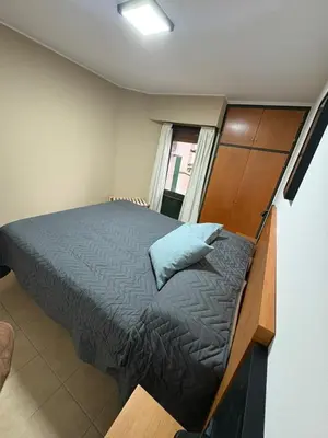 a bedroom with a large bed with a wooden headboard at Bv Illia - 1 dormitorio Bº Nueva Córdoba in Cordoba