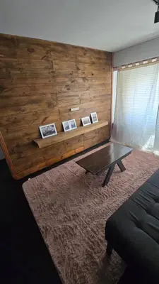 a living room with a wooden wall with a table at Elegante Depto 1 dorm pleno centro! in Cordoba