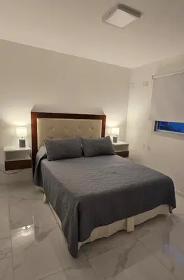 a bedroom with a large bed with two night stands at apartamento in Cordoba