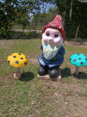 a statue of a gnome sitting in the grass at Wikam in Cordoba