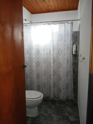 a bathroom with a toilet and a shower curtain at Wikam in Cordoba
