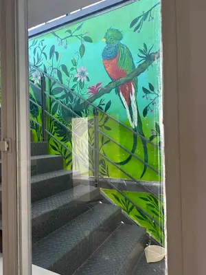 a mural of a bird sitting on a branch at departamentos apart quetzal in Villa Carlos Paz