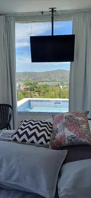 a bedroom with a bed and a large window at Anima Lodge in Villa Carlos Paz