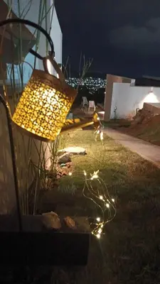 a lamp sitting on the grass in a yard at night at Anima Lodge in Villa Carlos Paz
